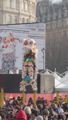 Vertikales-Video-Vom-Trafalgar-Square-In-London,-Großbritannien,-Mit-Menschenmassen,-Die-Das-Chinesische-Neujahr-2023-Mit-Löwentänzern-Auf-Der-Bühne-Feiern